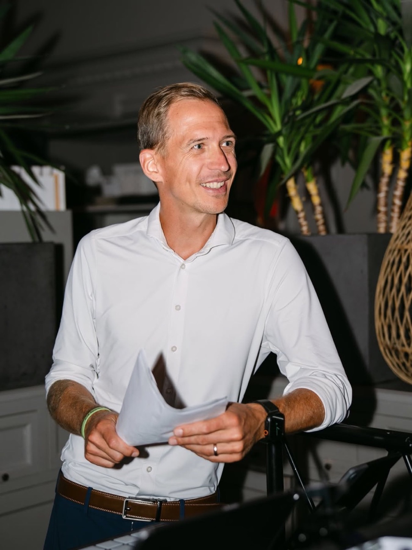 Chris mit Briefing-Zettel am Pult, das Pult nur angeschnitten im Vordergrund