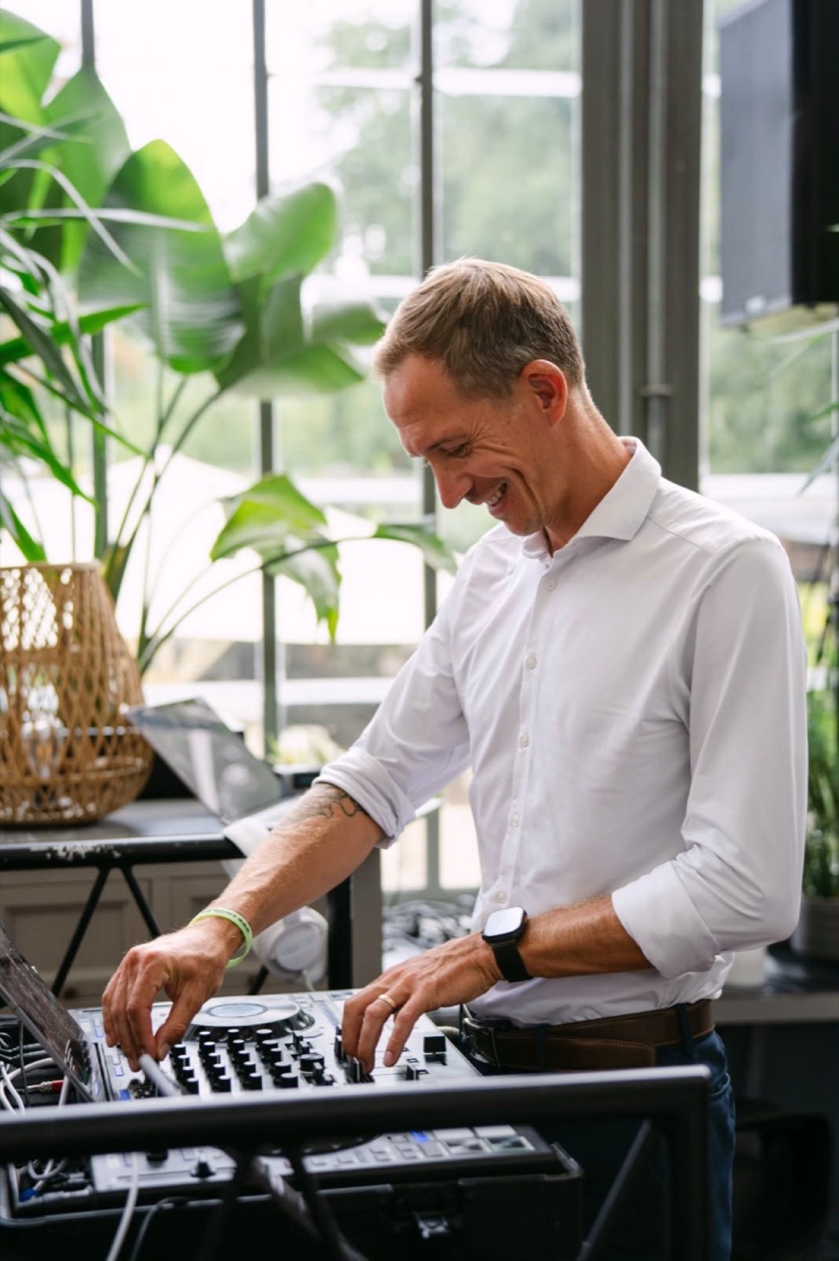 Chris am Pult in einer hellen Location mit Pflanzen