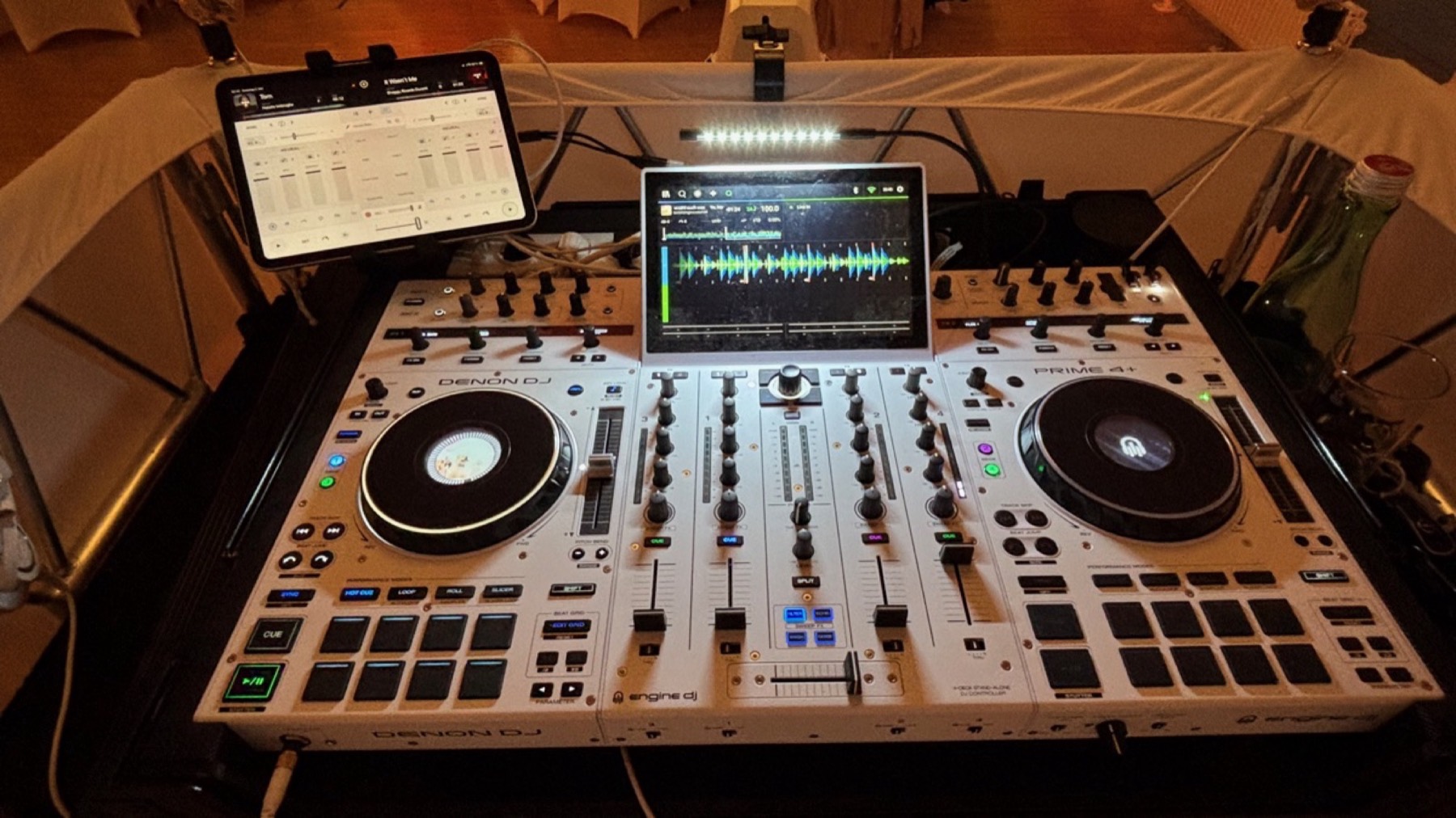 Weißes DJ-Pult mit Bildschirm am Abend, Lichtleiste darüber