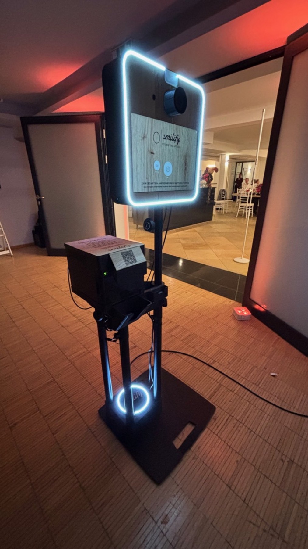 Fotobox im Vorraum, rechts unten ein roter Boden-Uplight, Türrahmen und Decke rot angestrahlt