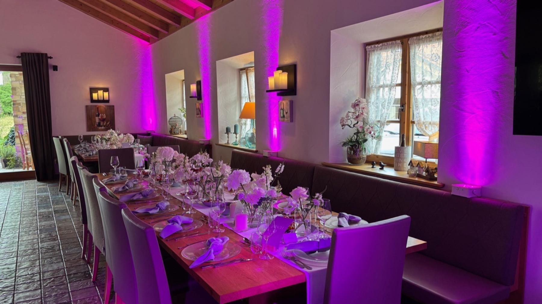 Derselbe Saal mit Uplights in Magenta auf Wänden und Säulen