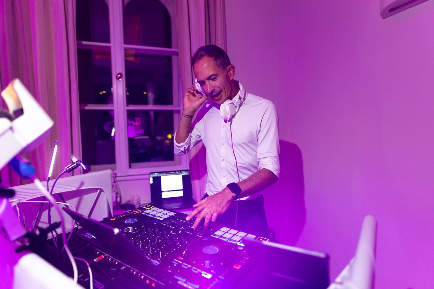 Chris Carter mit Kopfhörern am Pult in magentafarbenem Licht in der LA VILLA am Starnberger See